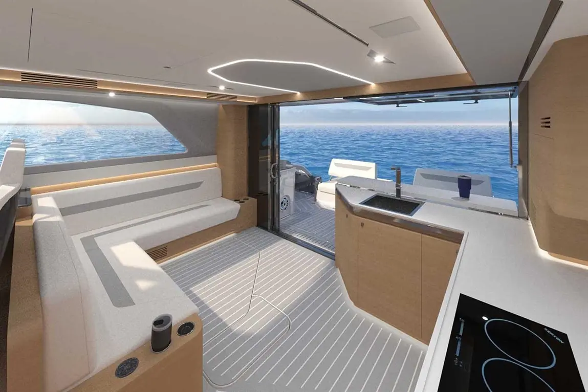 Modern yacht interior featuring a spacious lounge, kitchen area, and large windows overlooking the ocean.